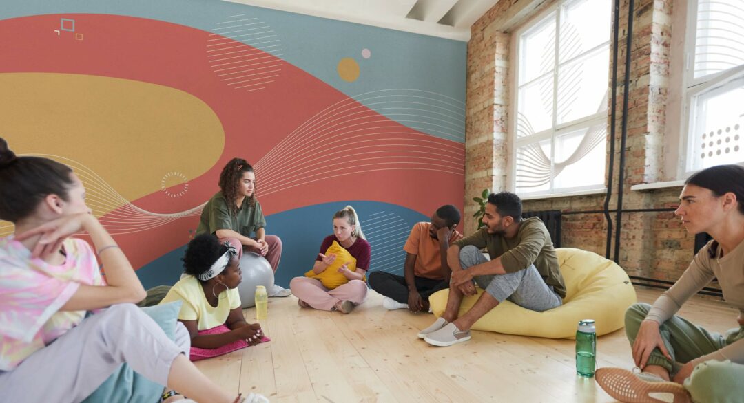 Des jeunes et des jeunes adultes discutent en cercle. Moment conviviale dans une décoration chaleureuse
