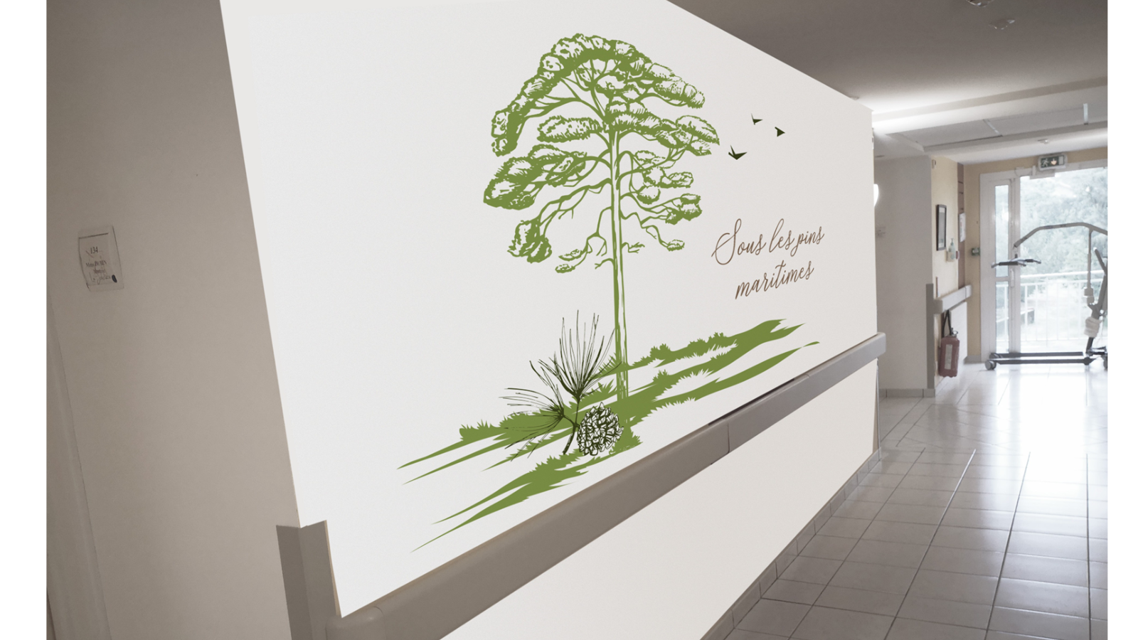 Décoration forestière apaisante : un grand pin maritime illustré sur un mur blanc, accompagné de l'inscription "Sous les pins maritimes", idéal pour créer une ambiance naturelle et relaxante dans les établissements de soins.