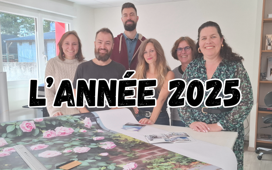 L'équipe de l'agence posant autour d'une table avec une grande impression de roses et le texte L'ANNÉE 2025.