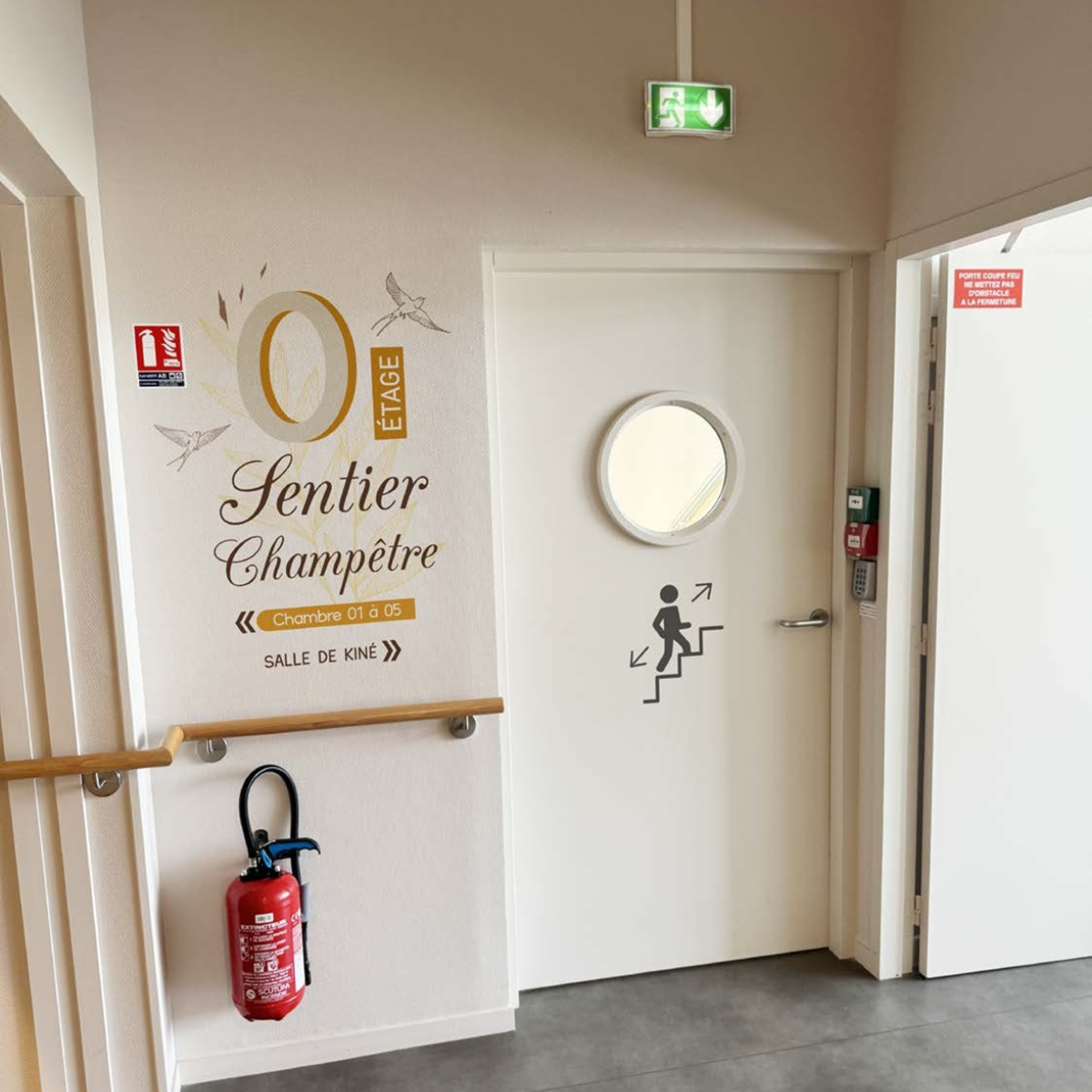 Signalétique murale et adhésifs de porte pour l'étage 0 "Sentier Champêtre" dans un établissement de santé.